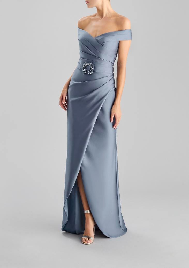 Convidada a usar um vestido longo cinza com um decote cai cai, adornado com um cinto ao redor da cintura