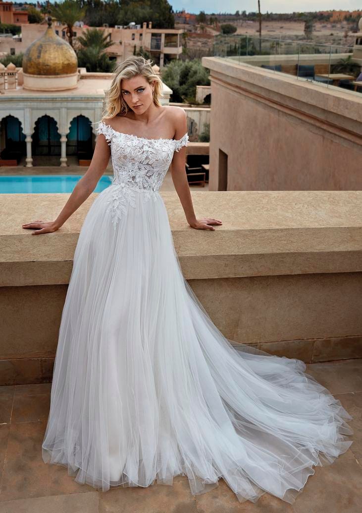 Robe de mariée romantique avec jupe en tulle Une belle femme blonde dans une robe de mariée romantique sans manches avec une jupe en tulle volumineuse.