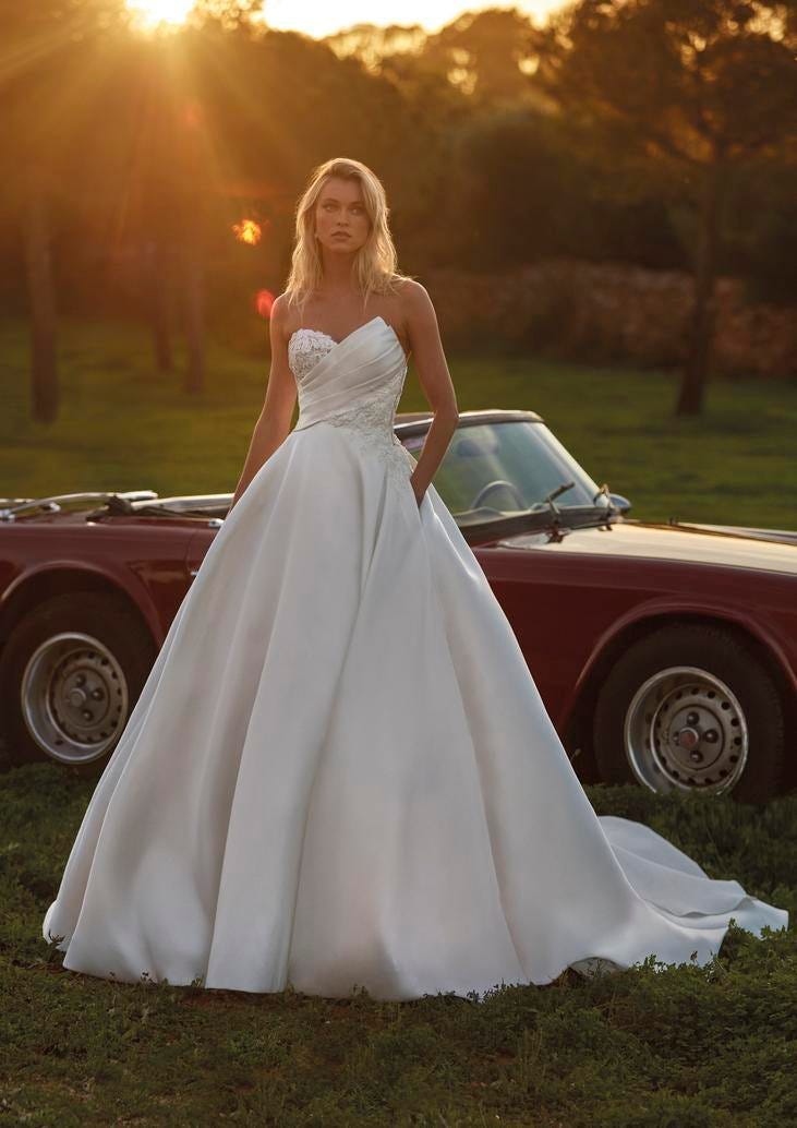 Donna con vestito da sposa liscio a principessa con scollo a cuore e corpetto con pizzo.