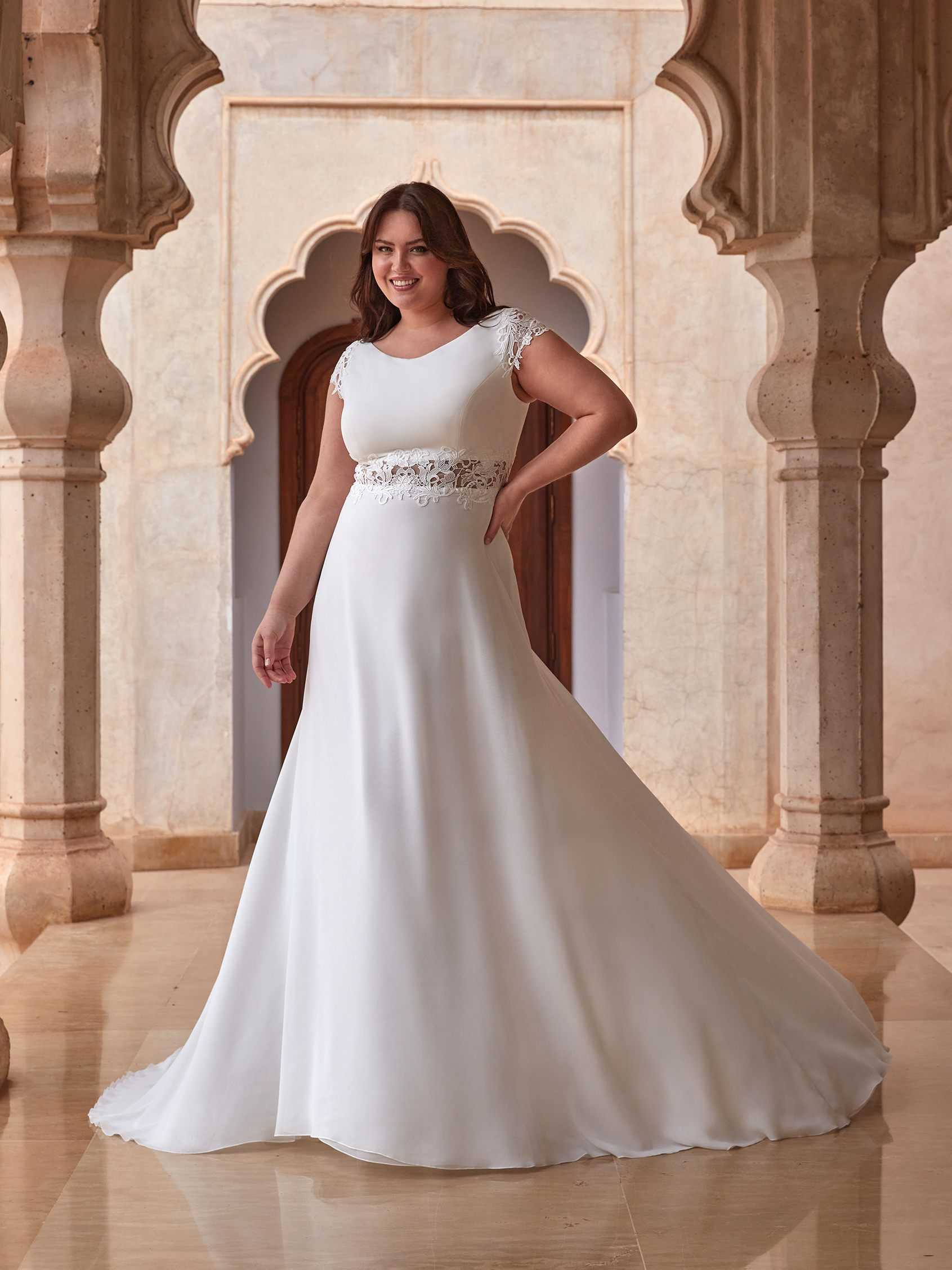 Mujer con el pelo suelto con segundo vestido de novia plus size de manga corta.