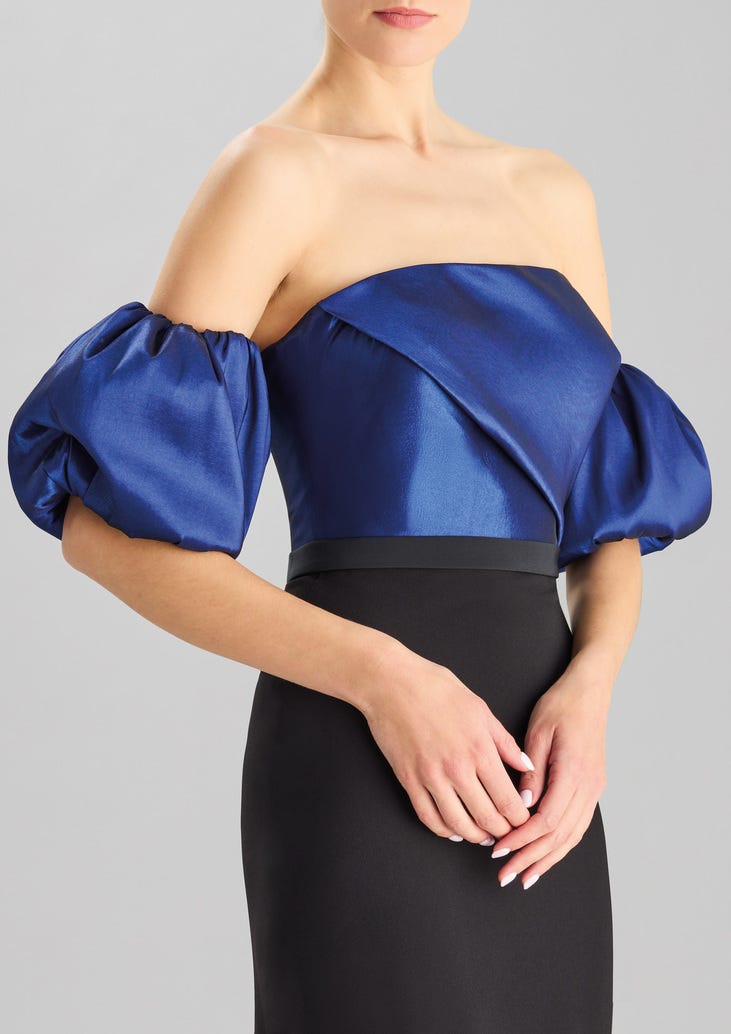 Frau in schwarzblauem kurzen Kleid stehend mit weißen Nägeln 