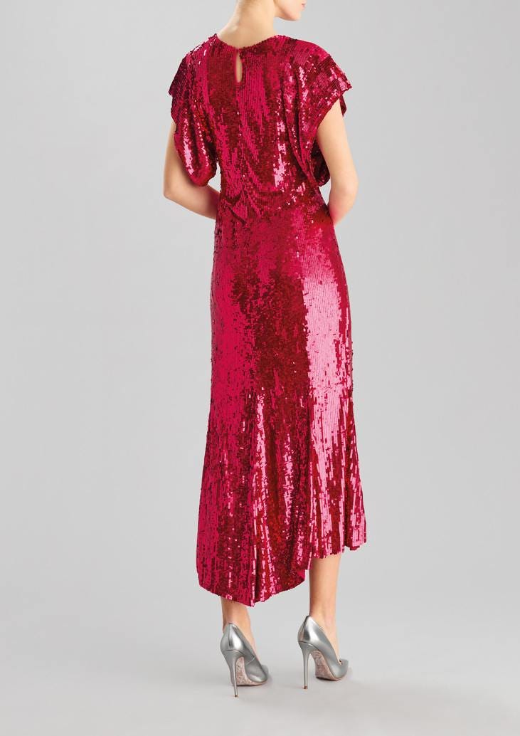 Woman wearing a pink fit and flare party gown in sequins and high heels, depicted from behind, against a grey background.